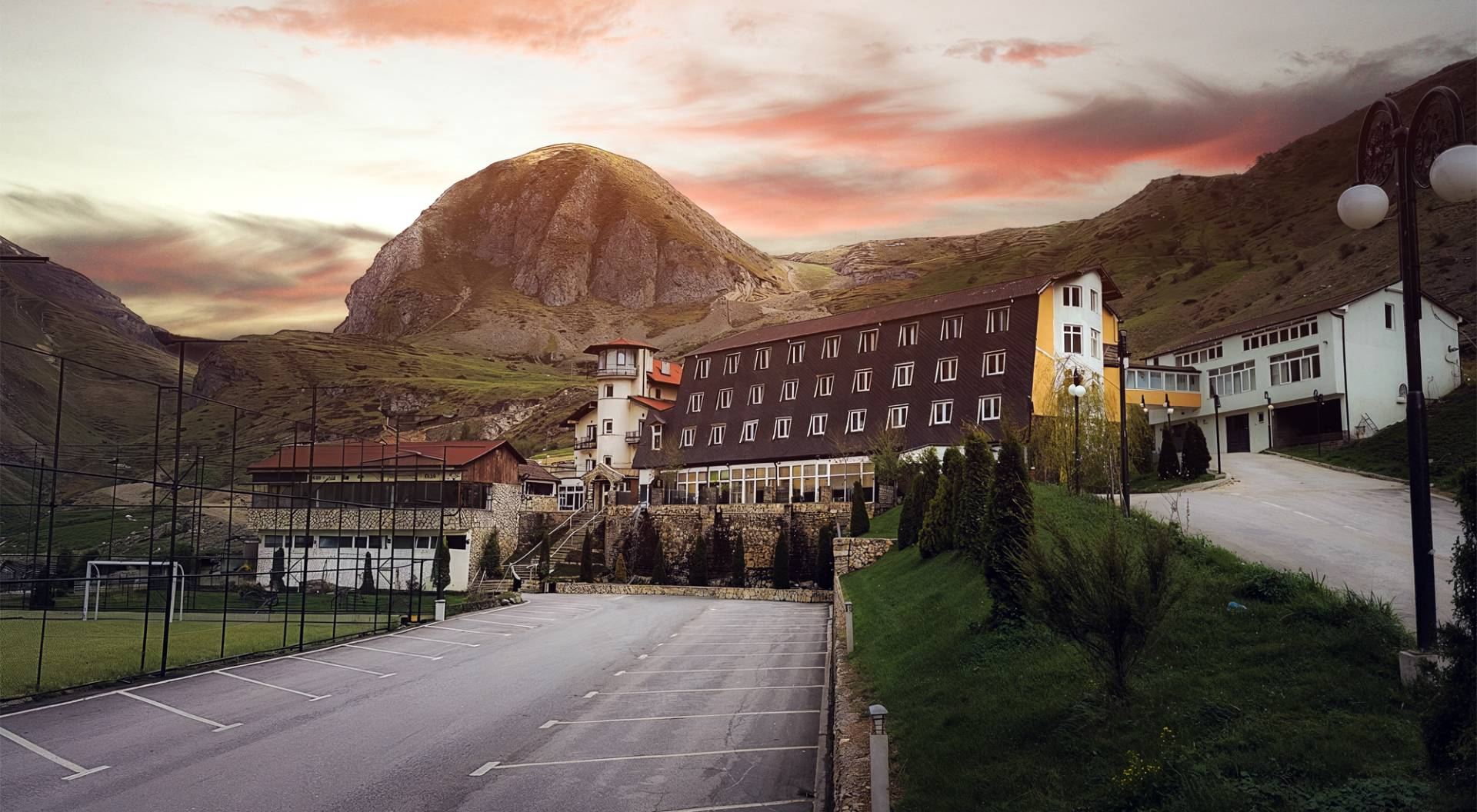 Hotel Arxhena në perëndim të diellit, me malin pas tij